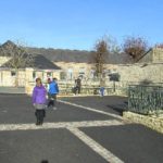 Entrée de l'école Alexis de Tocqueville avec des enfants et un ciel bleu